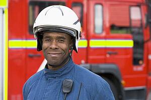 Fireman standing by fire engine wearing helmet