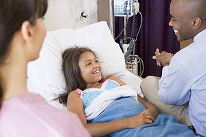 Doctor And Nurse Checking Up On Girl In Hospital