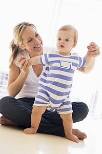 Mother and baby indoors playing and smiling