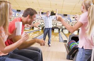 Family in bowling alley cheering and smiling