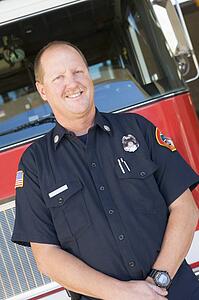 Fireman standing in front of fire engine
