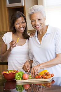 Mother And Daughter Preparing meal, mealtime Together