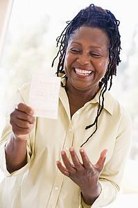 Woman with winning lottery ticket excited and smiling