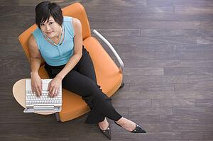 Businesswoman sitting indoors with laptop