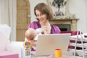 Mother and baby in home office with laptop