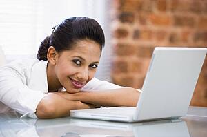 Businesswoman in office with laptop smiling