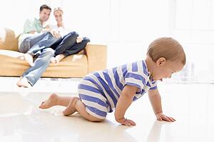 Couple in living room with baby smiling