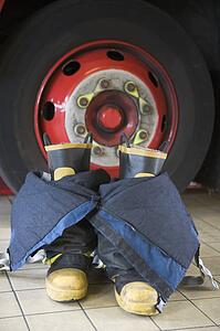Firefighting uniform on floor by fire engine