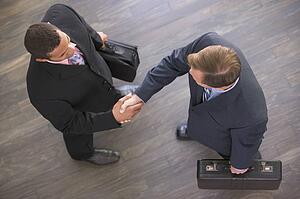 Two businessmen indoors shaking hands