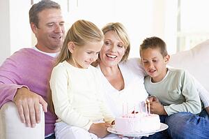 Family in living room with cake smiling