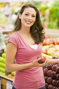 Woman shopping for apples at a grocery store