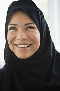Woman standing indoors smiling (high key)