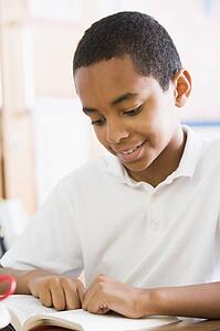Student in class reading book (high key)