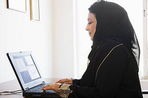 Woman in office with laptop (high key/selective focus)