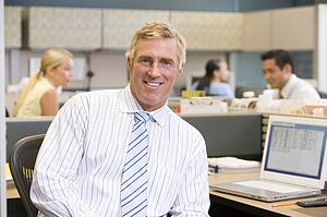 Businessman in cubicle smiling