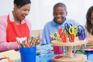 Teacher and student in art class with supplies in foreground (selective focus)
