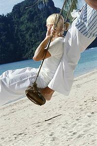 Couple on a swing outdoors at the beach