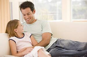 Man and young girl in living room smiling