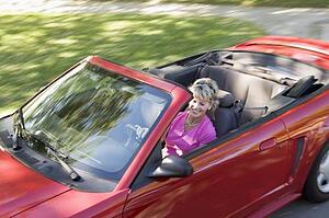 Woman in convertible car smiling