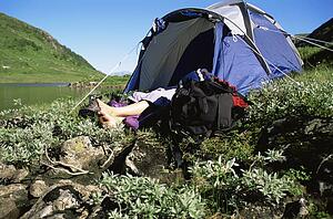 Camper outdoors sleeping at campsite by lake