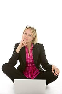 Businesswoman Sitting In Front Of Laptop Thinking