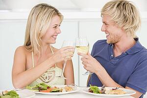 Young Couple Enjoying meal, mealtime With A Glass Of Wine