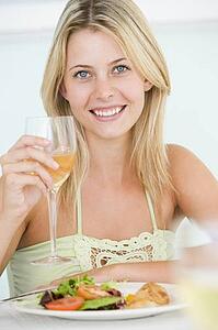 Young Woman Enjoying meal, mealtime With A Glass Of Wine
