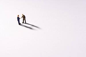Figurines Of Two Businessmen Shaking Hands