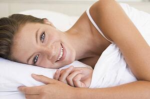 Woman lying in bed smiling