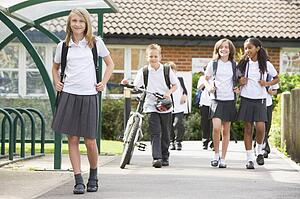 Students leaving school one with a bicycle