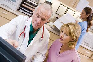 A Doctor And Nurse Discussing Something At The Reception Area Of A Hospital