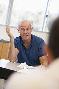 Adult student in class with teacher looking confused (selective focus)