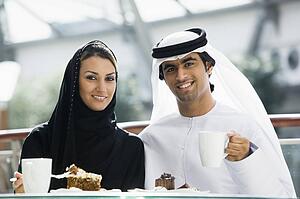 Couple at restaurant eating dessert and smiling (selective focus)