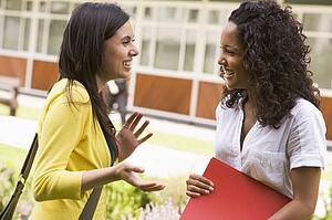 Two students standing outdoors talking