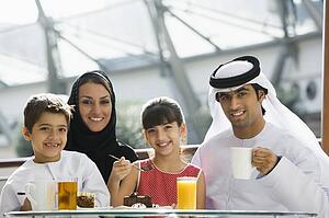Family at restaurant eating dessert and smiling (selective focus)