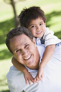 Grandfather piggryback riding grandson.