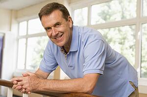 Teacher in corridor leaning on railing