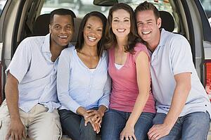 Two couples sitting in back of van smiling