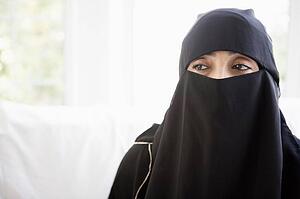 Woman wearing black veil indoors (high key)