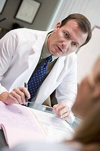 Doctor in consultation with woman at IVF clinic (selective focus)