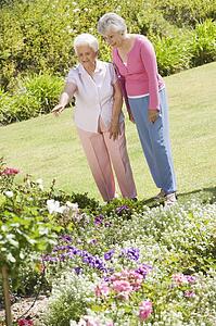 Two senior women in a flower garden