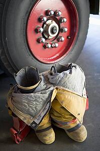 Firefighting uniform on floor near fire engine