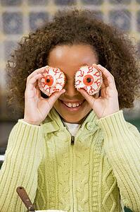 Young girl at Halloween playing with treats and smiling