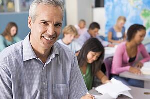Students studying in geography class with teacher
