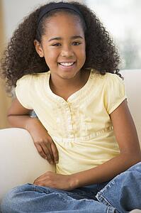 Young Girl Sitting On A Sofa At Home