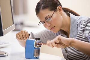 Woman in computer room using pencil sharpener