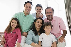 Family sitting in living room smiling (high key)