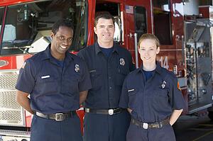 Three firefighters standing in front of fire engine