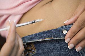 Woman injecting drugs to prepare for IVF treatment