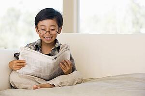 Young Buy Sitting On A Sofa At Home, Pretending To Be A Grown Up